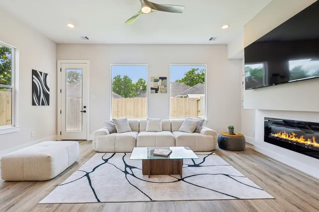 a living room with furniture a flat screen tv and a fireplace
