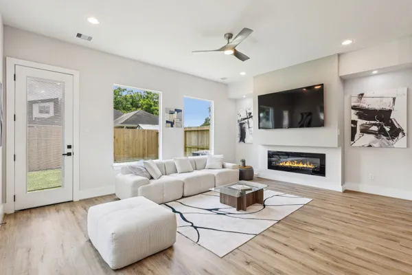a living room with furniture a fireplace and a flat screen tv