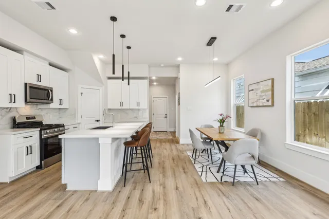 a large kitchen with cabinets wooden floor and stainless steel appliances