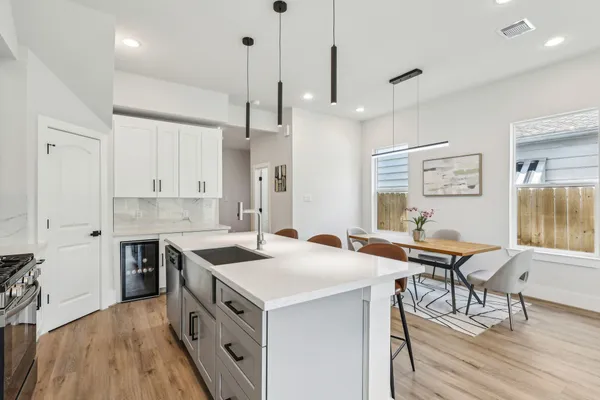 a kitchen that has a lot of cabinets in it and wooden floors
