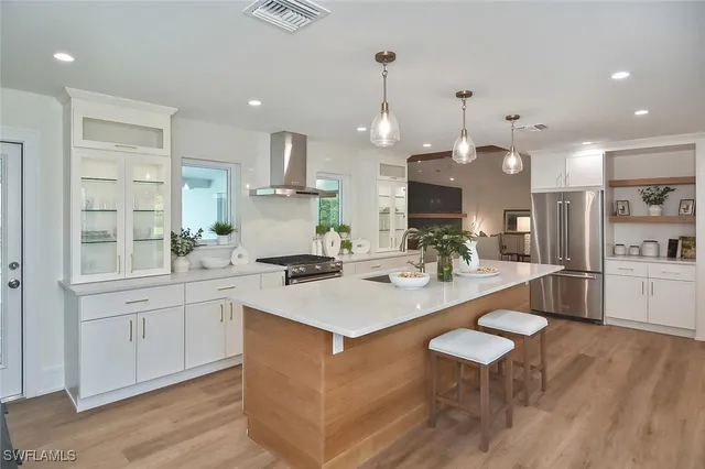a kitchen with stainless steel appliances granite countertop a refrigerator and a sink