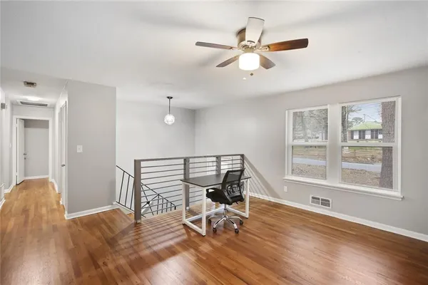 a view of a workspace with wooden floor and a window