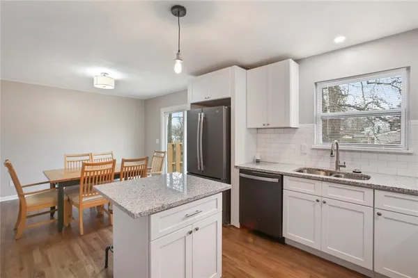 a kitchen with a sink a center island cabinets and a wooden floor