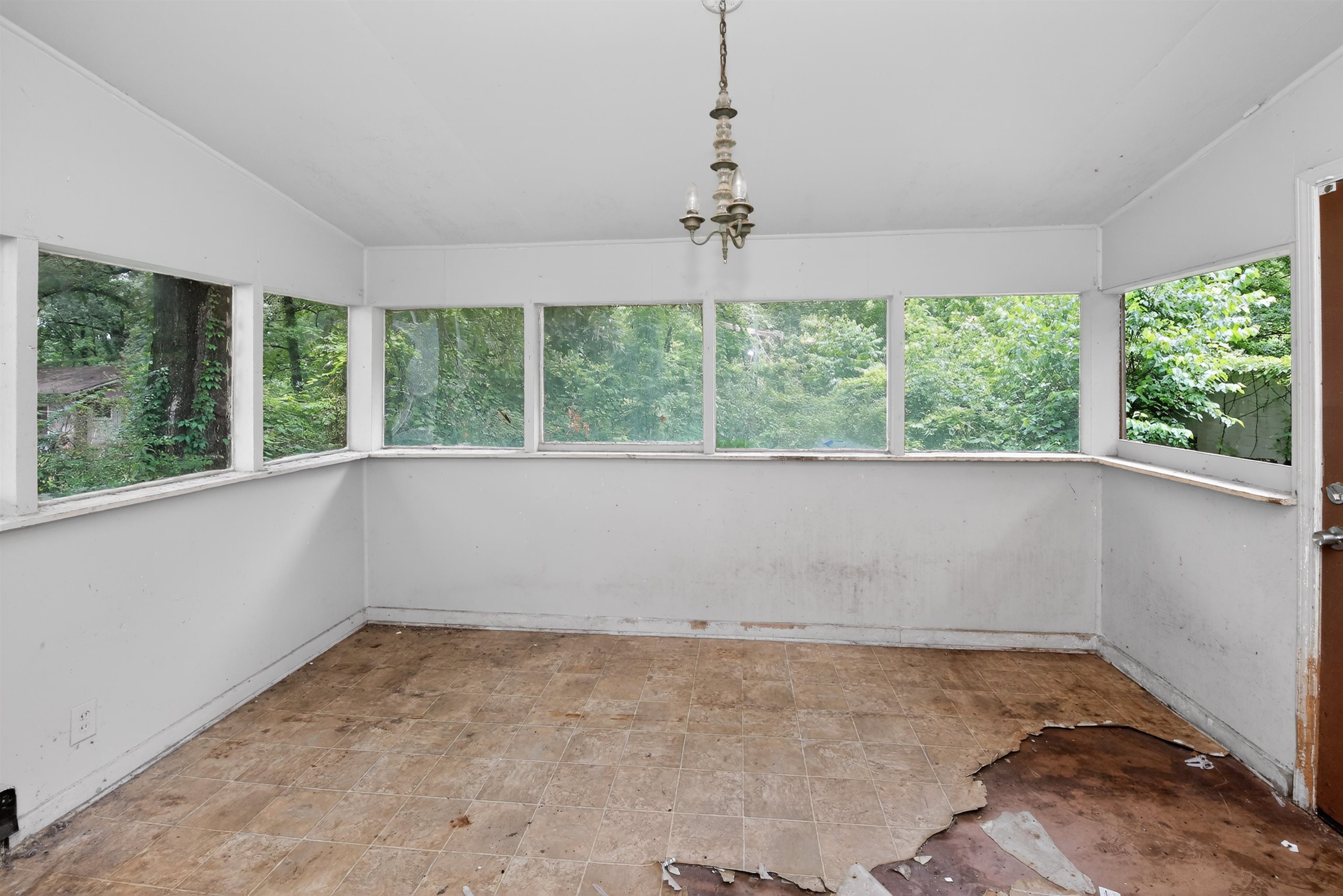 810 Hale Road Memphis, TN 38116 - Photo 25 of 30 Room featuring extensive window placement, a ceiling-mounted light fixture, and a brown paneled door