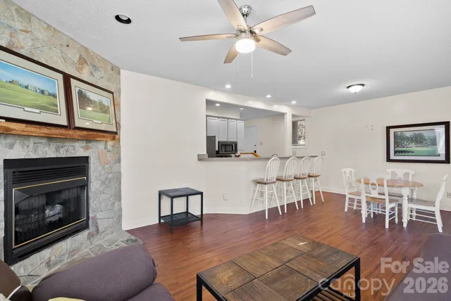 a living room with furniture a fireplace and wooden floor