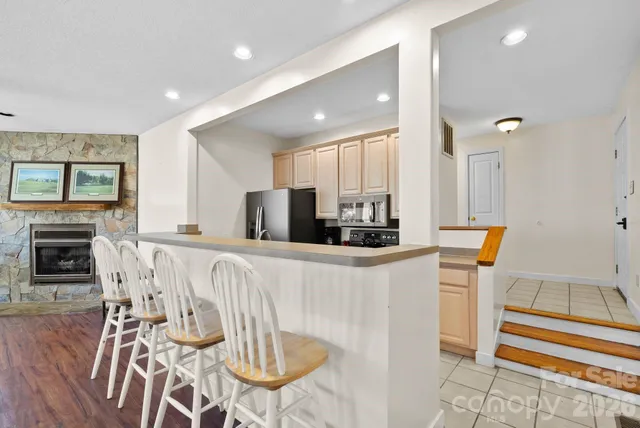 a kitchen with stainless steel appliances a dining table chairs and a refrigerator