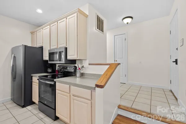 a kitchen that has a microwave a sink and a refrigerator