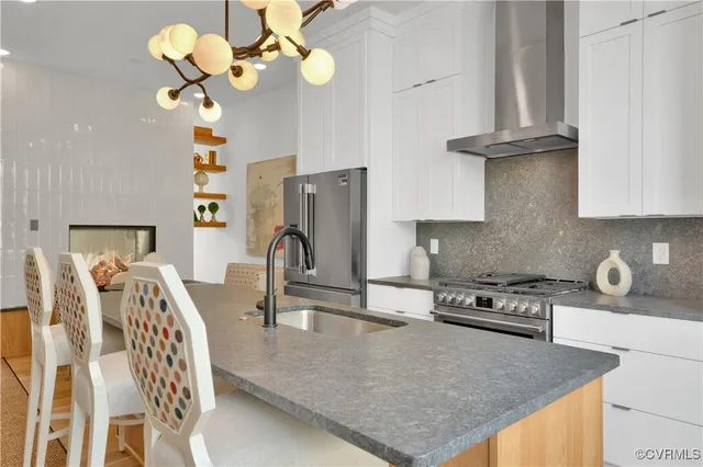 a kitchen with stainless steel appliances granite countertop a sink a stove and a refrigerator