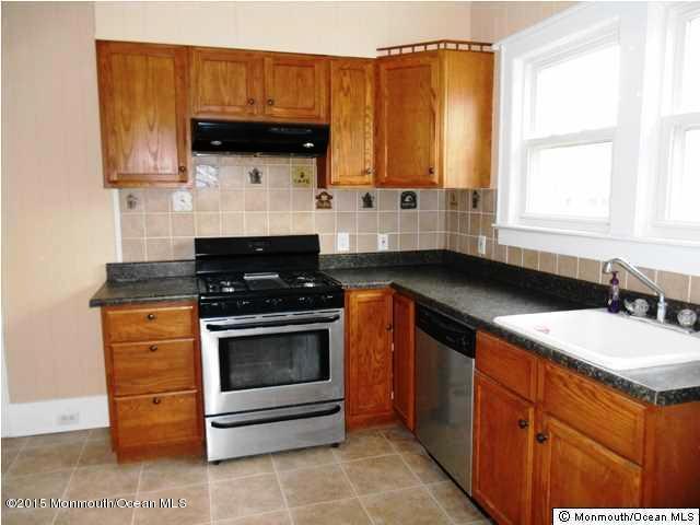 7-a-b Ellis Street Freehold, NJ 07728 - Photo 2 of 23 a kitchen with granite countertop a stove top oven microwave and cabinets