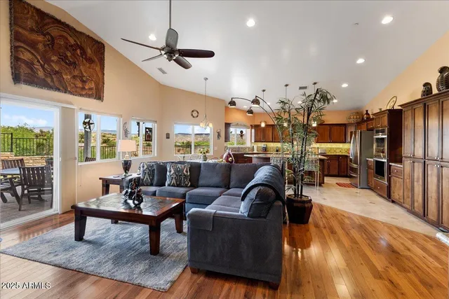 a living room with furniture kitchen view and a wooden floor