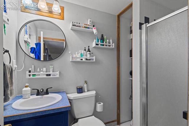 28079 Iris Road Pueblo, CO 81006 - Photo 21 of 50 Bathroom featuring a shower with door, vanity, and toilet