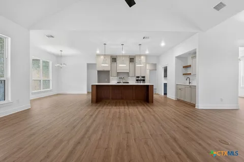 a kitchen with a table chairs and a chandelier