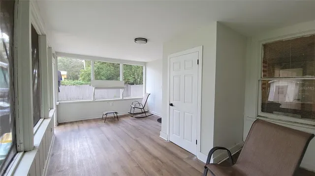 a view of a livingroom with wooden floor and a bathroom