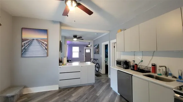 a view of a livingroom with furniture hardwood floor and a ceiling fan