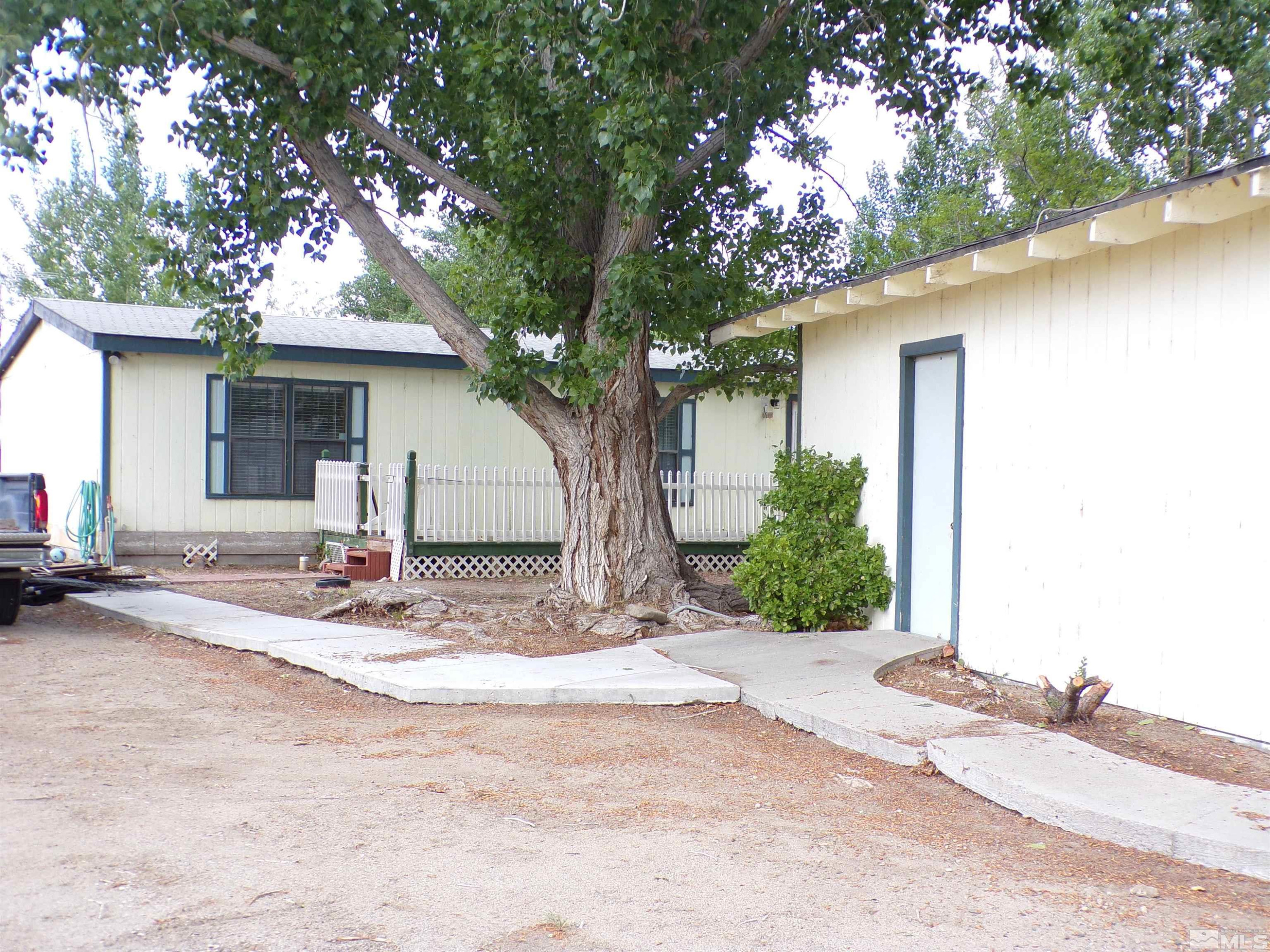 a view of a trees with house in the background
