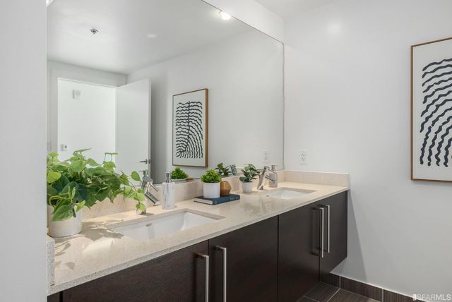a bedroom with a large bed and a potted plant