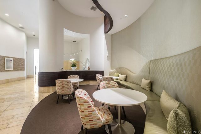 a view of a patio with couches chairs potted plants and wooden floor