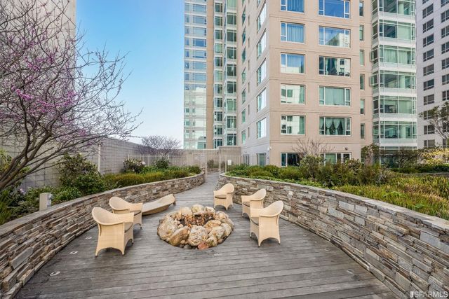 a kitchen with stainless steel appliances granite countertop a stove two chairs and a refrigerator