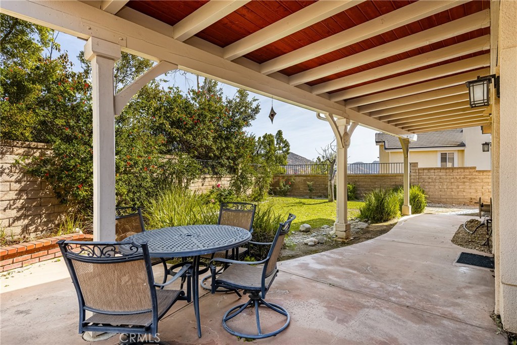 3250 North Geronimo Avenue Simi Valley, CA 93063 - Photo 26 of 47 a view of a patio with table and chairs potted plants with wooden floor and fence