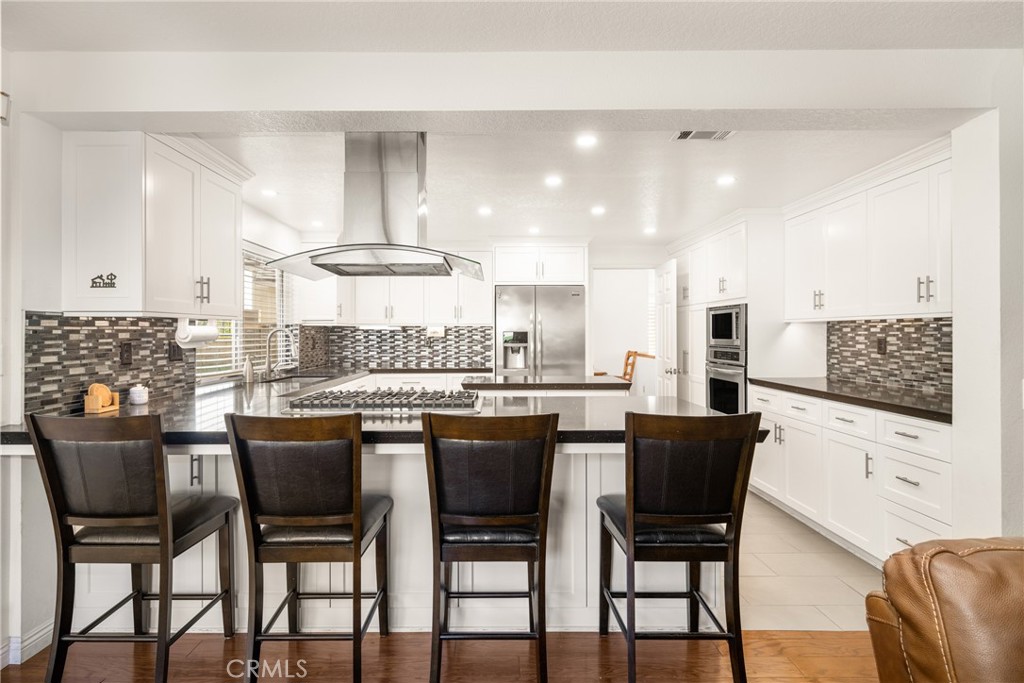 3250 North Geronimo Avenue Simi Valley, CA 93063 - Photo 4 of 47 a kitchen with a dining table chairs and white cabinets