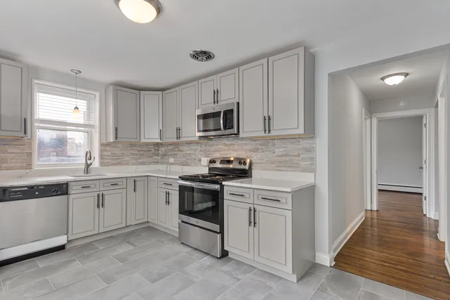 a kitchen with granite countertop cabinets stainless steel appliances and a sink