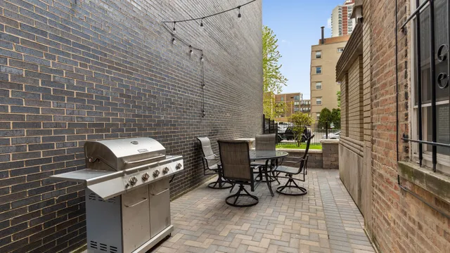 a view of a patio with table and chairs and barbeque