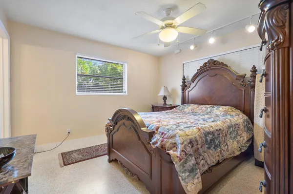 a bedroom with a bed ceiling fan and a window