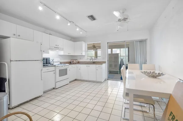 a kitchen with a sink appliances cabinets and furniture