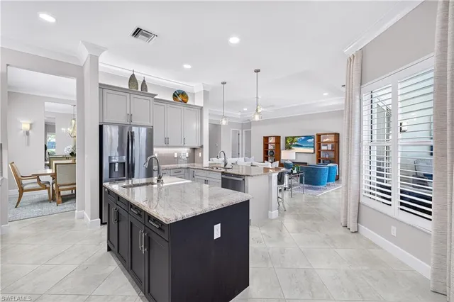 a kitchen with granite countertop a sink a counter top space and living room view