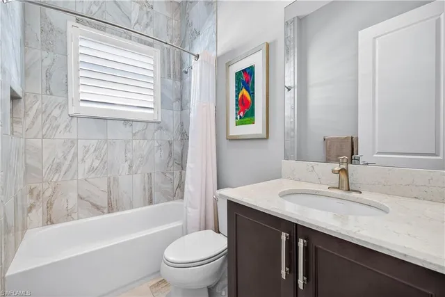a bathroom with a granite countertop toilet a sink and a mirror