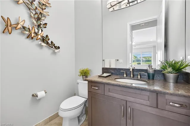 a bathroom with a granite countertop sink toilet a mirror and shower