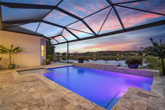 a view of swimming pool with a table and chairs under an umbrella