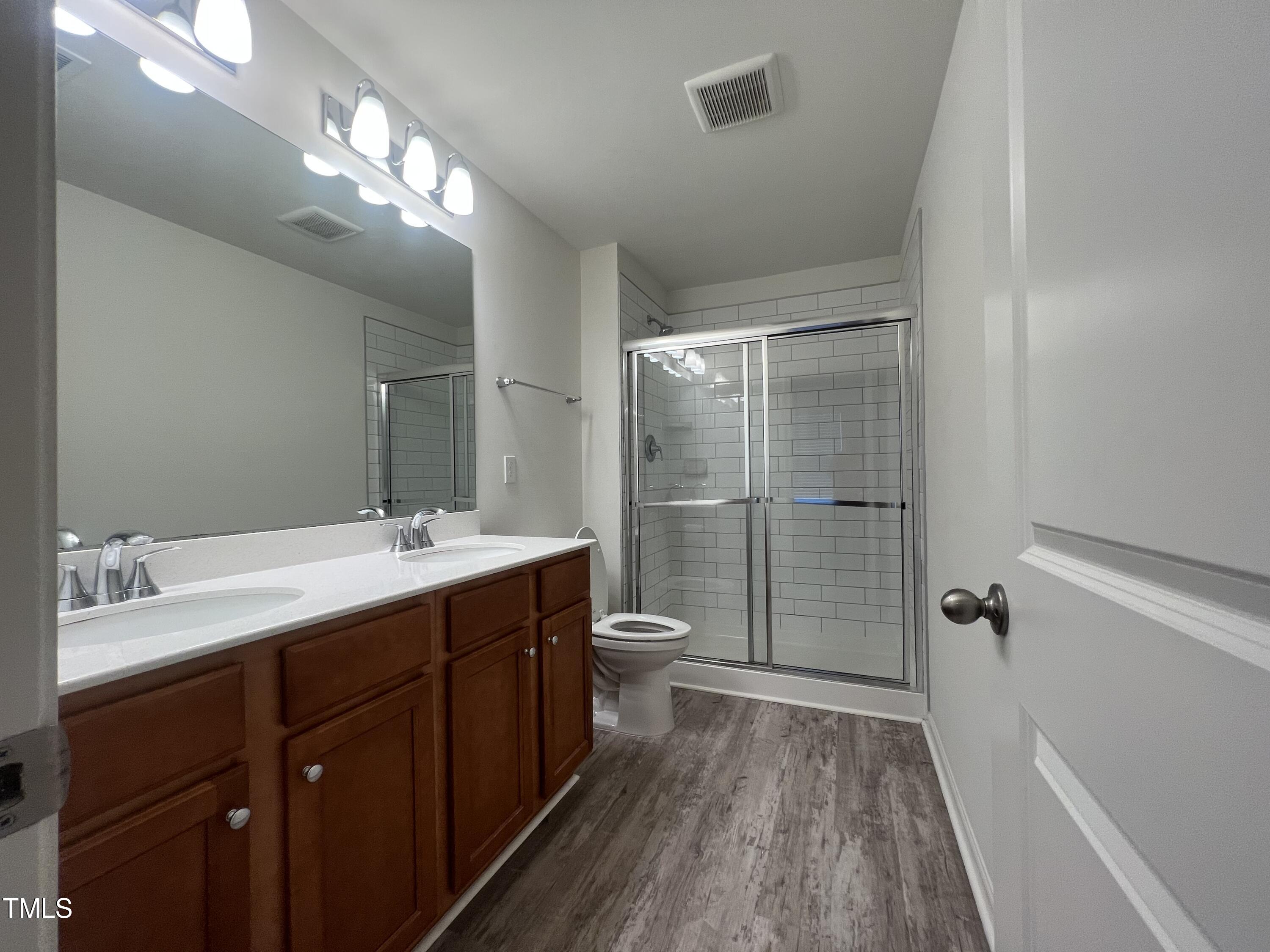 3118 Crater Loop Raleigh, NC 27610 - Photo 11 of 14 a bathroom with a double vanity sink toilet and shower