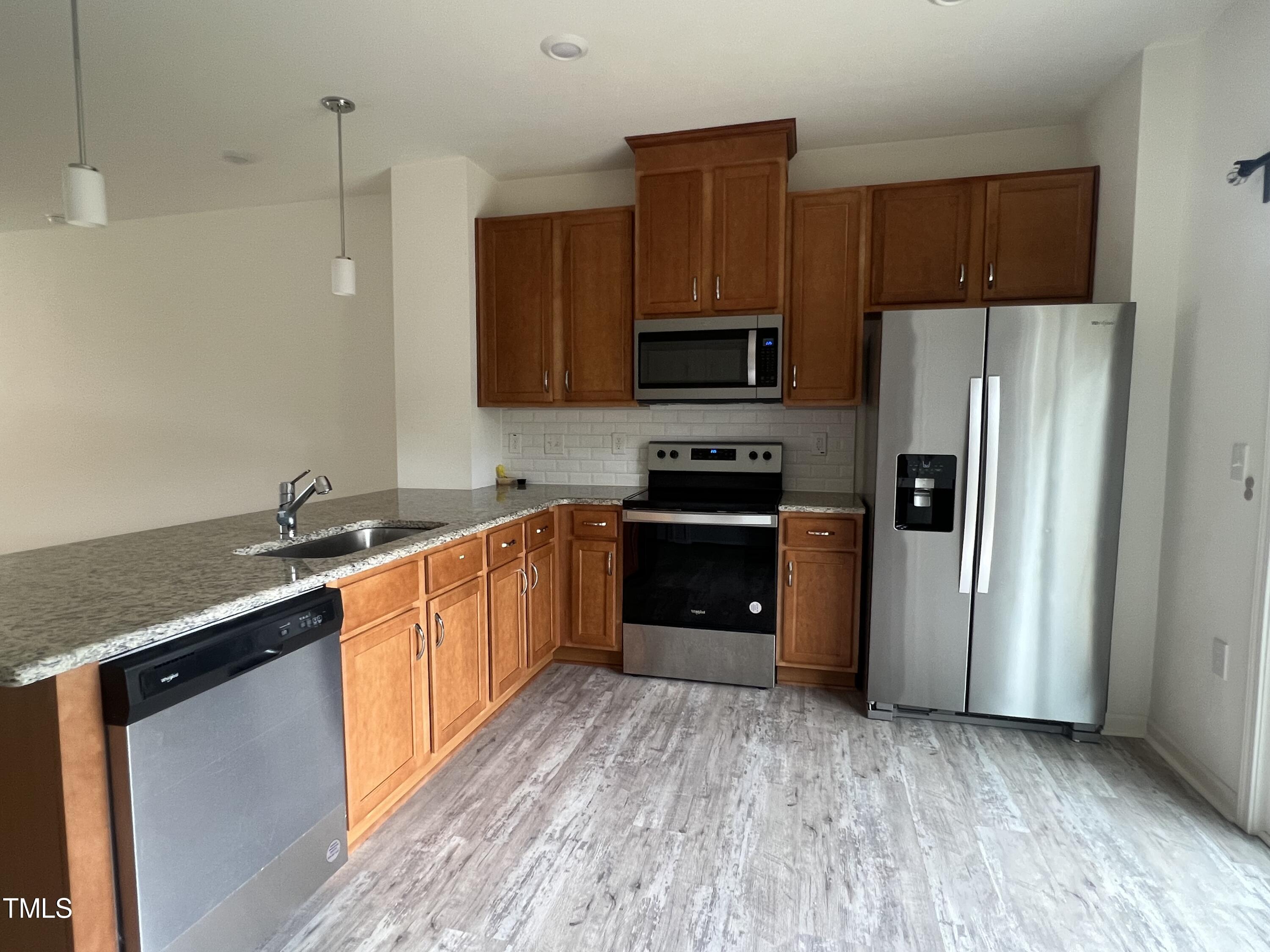 3118 Crater Loop Raleigh, NC 27610 - Photo 8 of 14 a kitchen with stainless steel appliances granite countertop a refrigerator a stove top oven a sink and dishwasher with wooden floor
