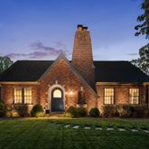 a front view of a house with a garden and plants