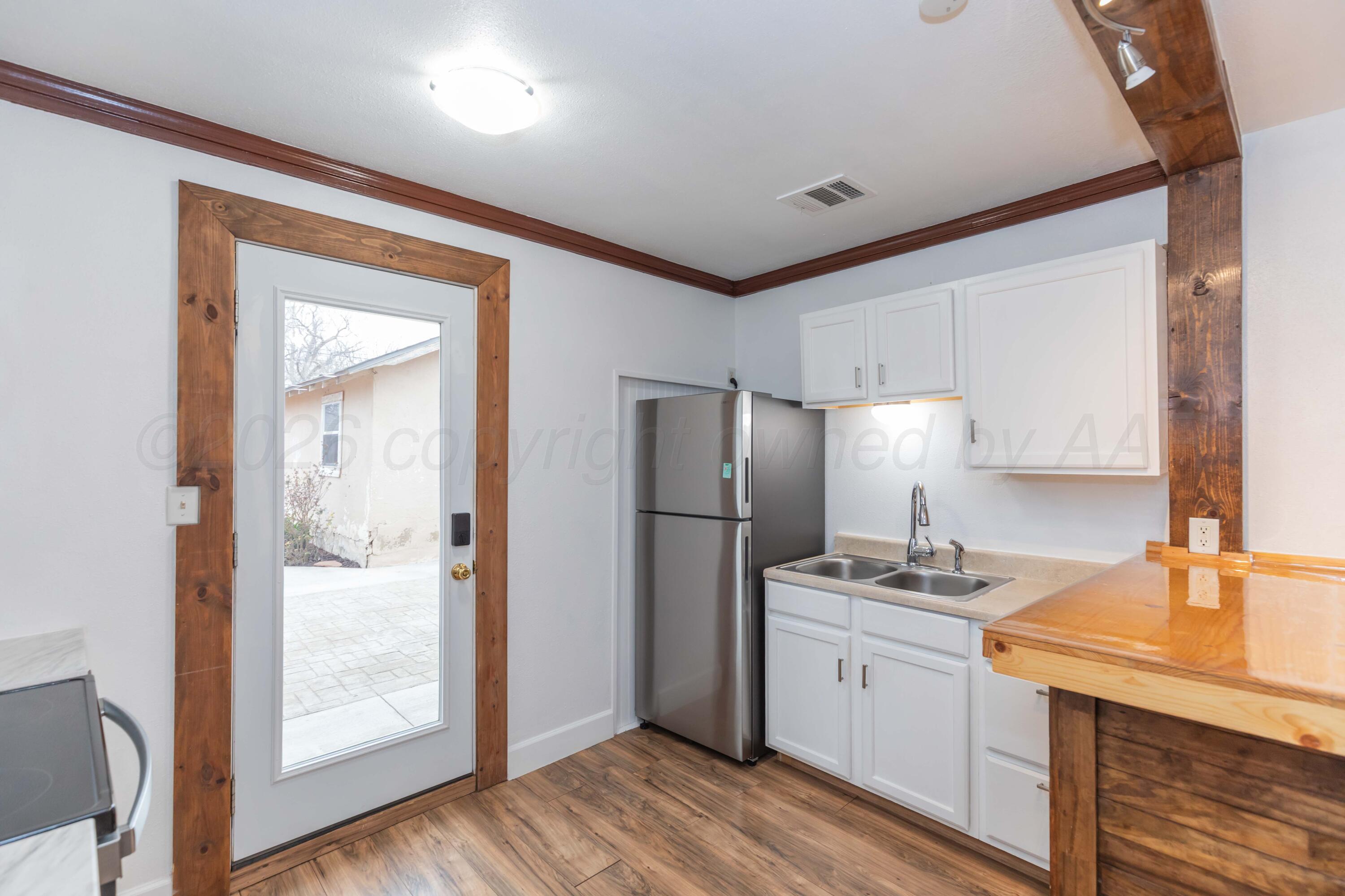 1503 7th Avenue Canyon, TX 79015 - Photo 14 of 30 a kitchen with a refrigerator sink and cabinets