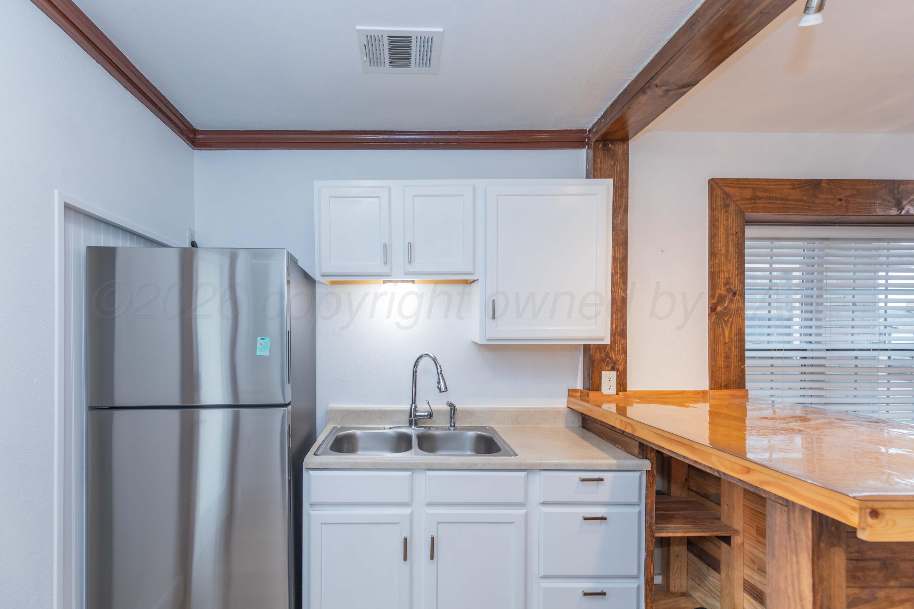 1503 7th Avenue Canyon, TX 79015 - Photo 15 of 30 a kitchen with appliances a sink and a window