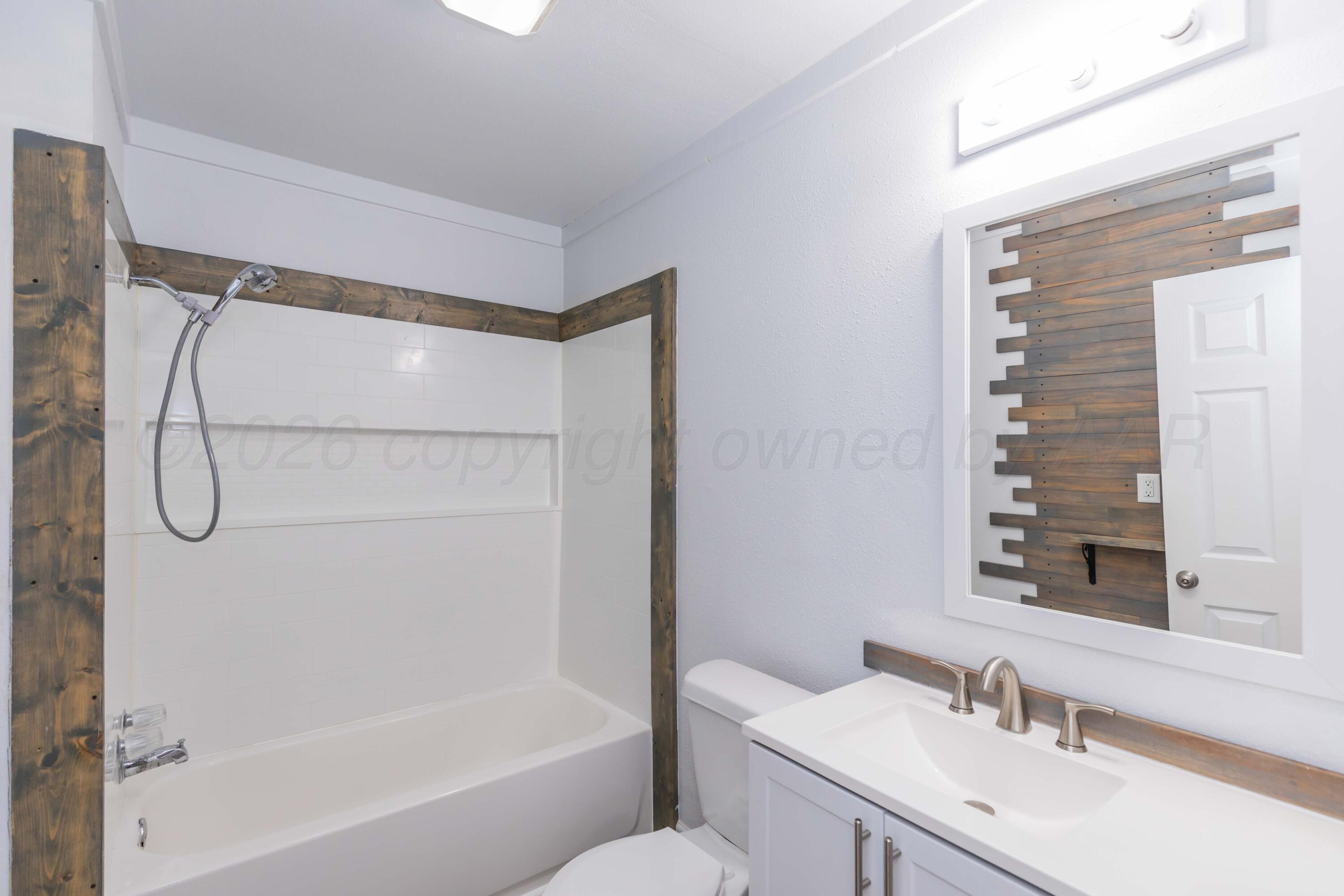 1503 7th Avenue Canyon, TX 79015 - Photo 6 of 30 a bathroom with a granite countertop sink a toilet and shower