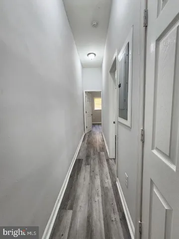 a view of a hallway with wooden floor and staircase