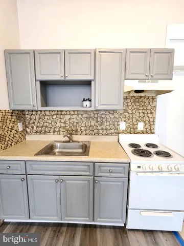 a kitchen with granite countertop a sink and a stove