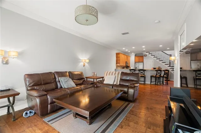 a living room with furniture a wooden floor and chandelier
