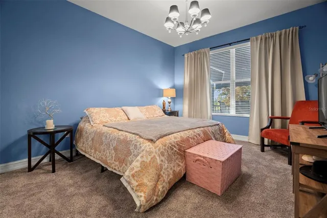 a bedroom with a bed and a chandelier