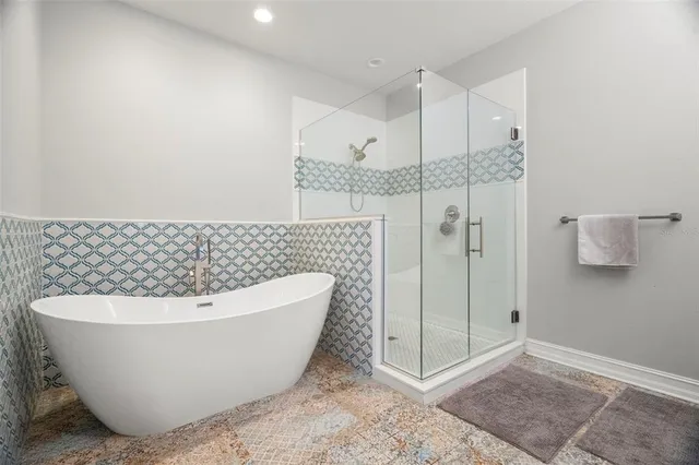 a white tub sitting next to a shower