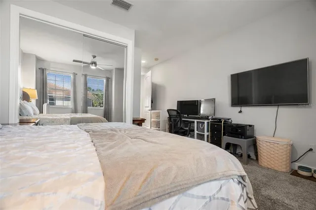 a bedroom with a bed and a flat tv screen on wall
