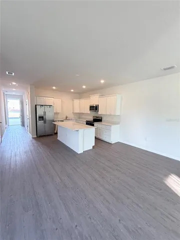 a view of a living room kitchen with furniture and wooden floor