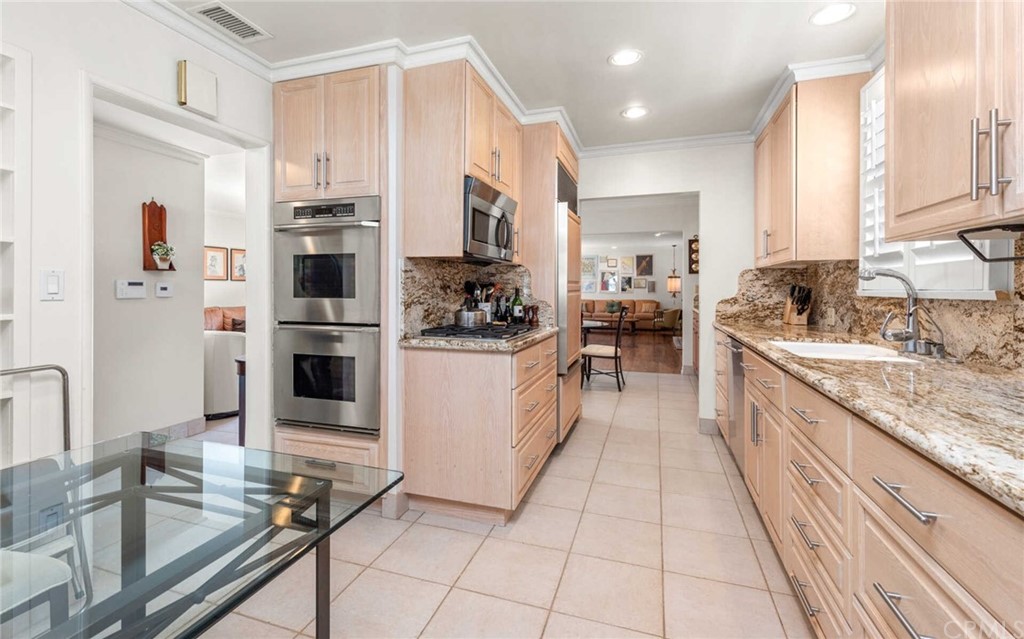 3381 Colbert Avenue Mar Vista, CA 90066 - Photo 10 of 23 a large white kitchen with stainless steel appliances kitchen island granite countertop a large counter top a stove a chimney a sink and cabinets