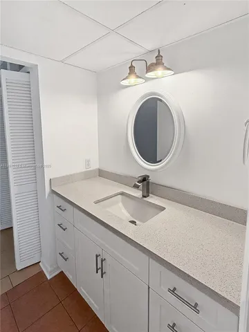 a bathroom with a granite countertop sink and a mirror