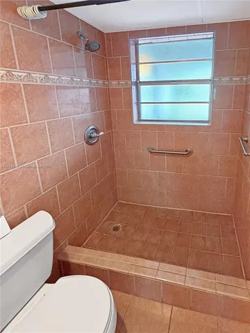 a bathroom with a toilet and a shower