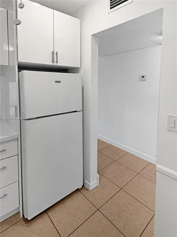 a white refrigerator freezer and a stove sitting inside of a kitchen