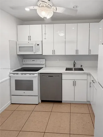 a kitchen with cabinets appliances and a sink